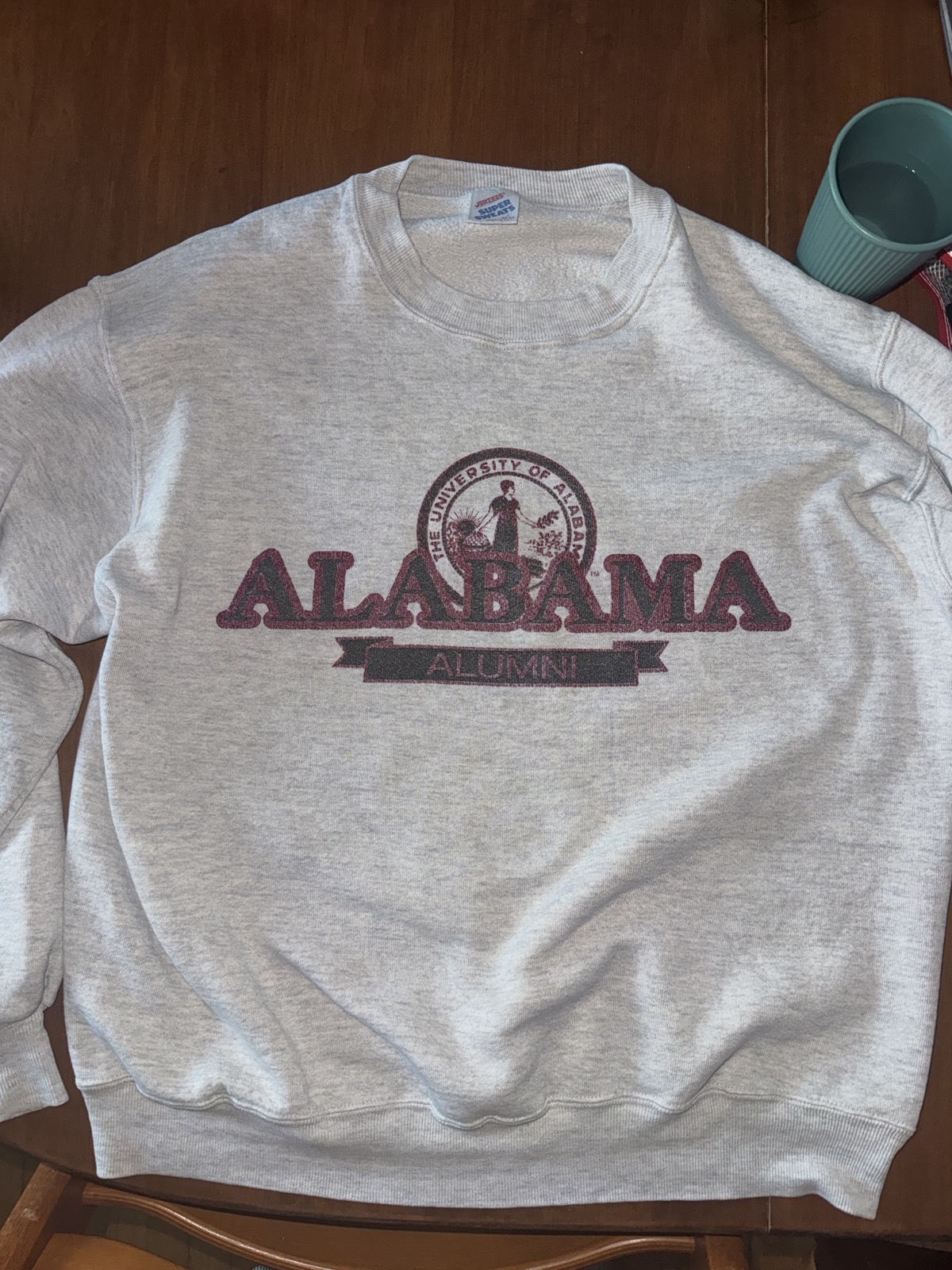 Front: outline ALABAMA over university seal and ALUMNI banner on ash gray
