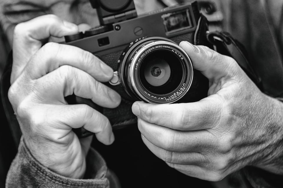 Leica M10-D held in two hands with a Zeiss lens