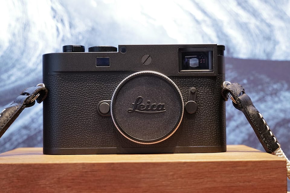 Leica M11 Monochrom body, front view on a wooden block
